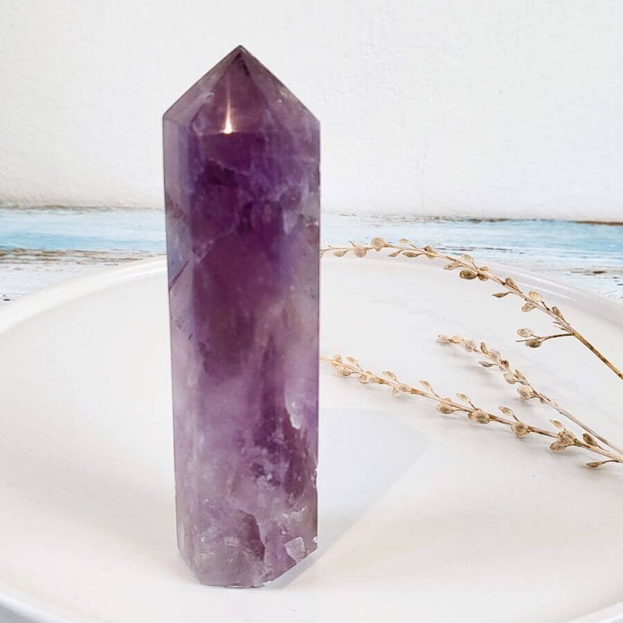 Schlanker Amethyst-Turm auf einem Dekoteller