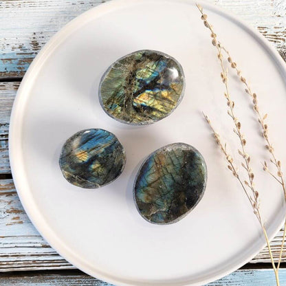Drei Labradorit-Edelsteine als Emu Egg auf einem Dekoteller